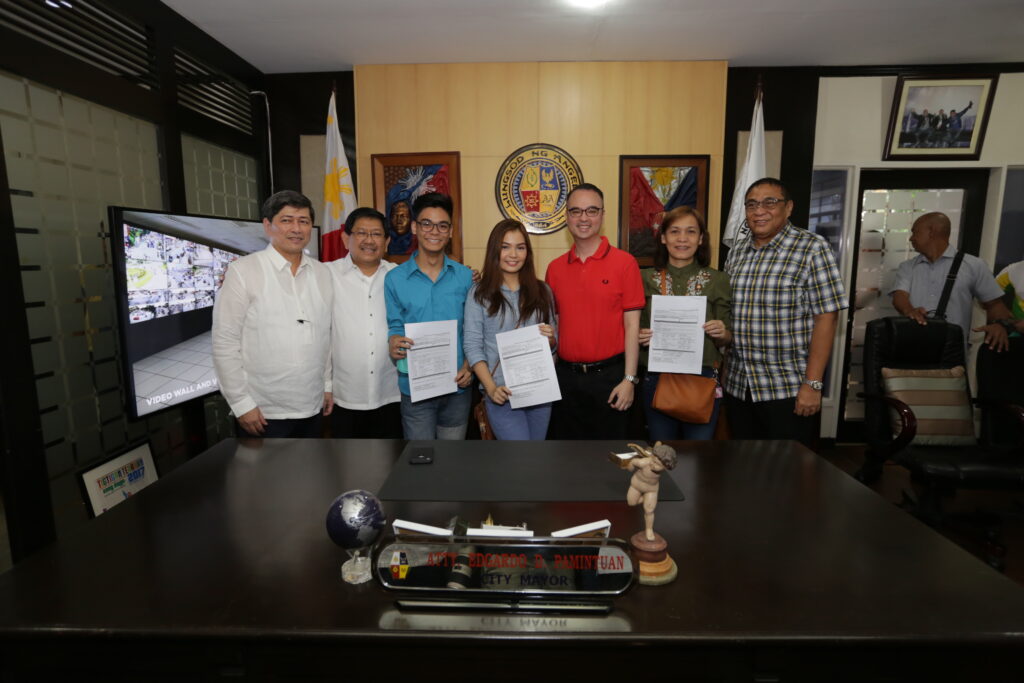 Alan Peter Cayetano participates in a ceremony, possibly related to local governance or community projects, with signed documents.