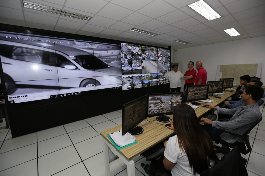 Alan Peter Cayetano observes a high-tech surveillance room, possibly related to public safety and urban monitoring initiatives.