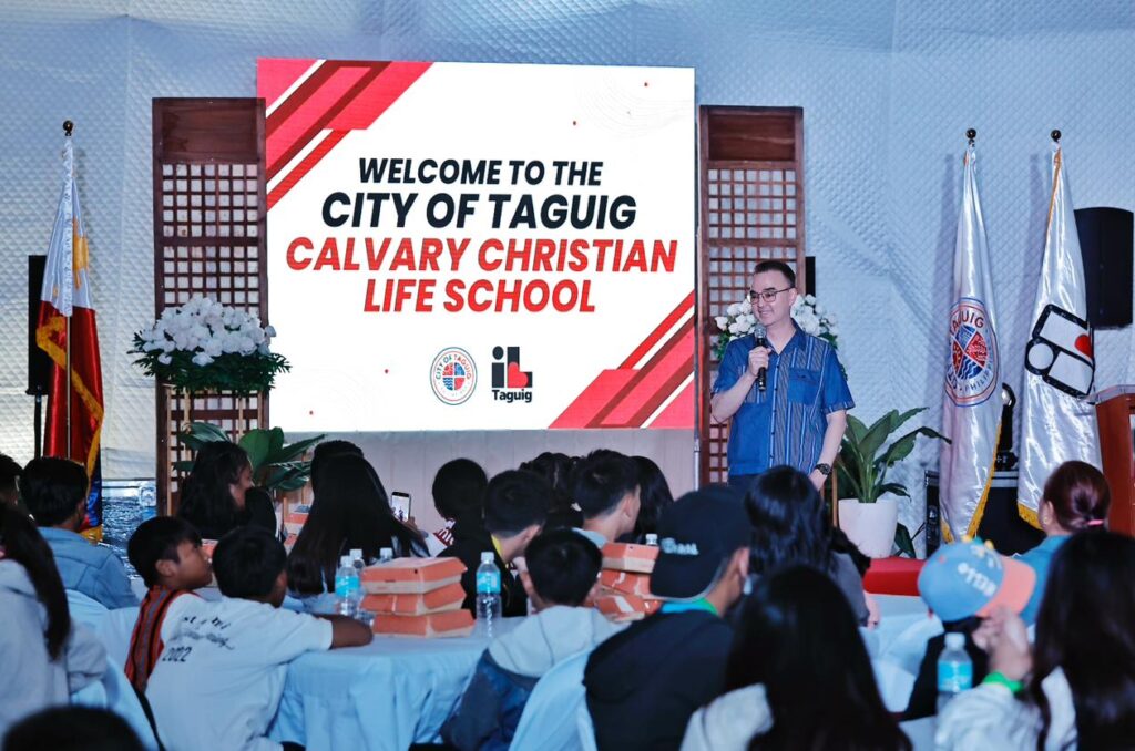 Alan Peter Cayetano speaks at a City of Taguig Calvary Christian Life School event, welcoming attendees and engaging the audience.