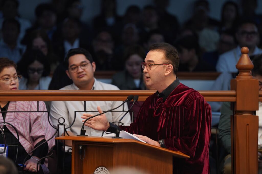 Alan Peter Cayetano, in judicial robes, addresses an audience, presenting arguments, engaging in legal discourse, and upholding justice from the podium.