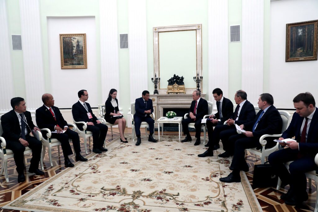 Alan Peter Cayetano, Rodrigo Duterte and Vladimir Putin hold formal discussions, joined by their delegations, in an official and diplomatic setting.